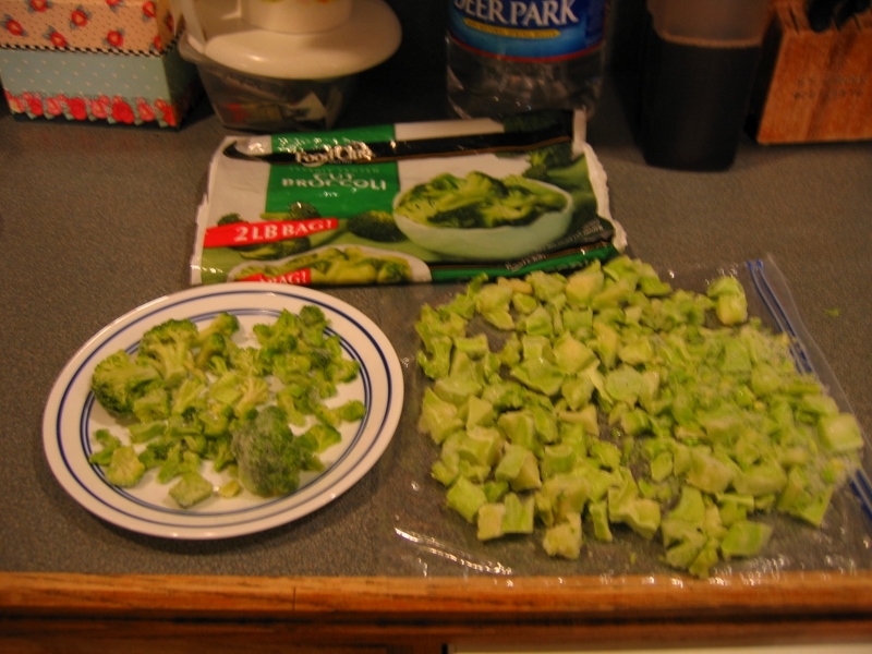 A small saucer of broccoli sits, bereft, beside a large pile of stems.